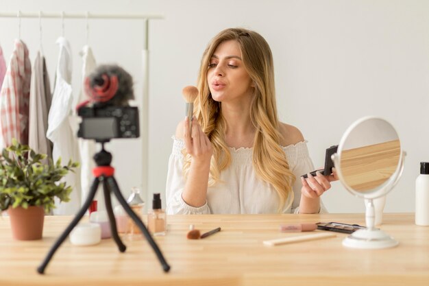 Mujer sosteniendo pincel de maquillaje