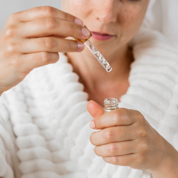 Mujer sosteniendo una pipeta con crema hidratante