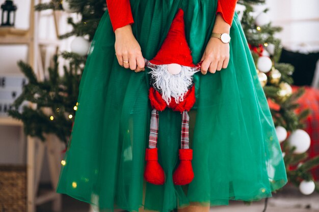 Mujer sosteniendo poco juguete de santa