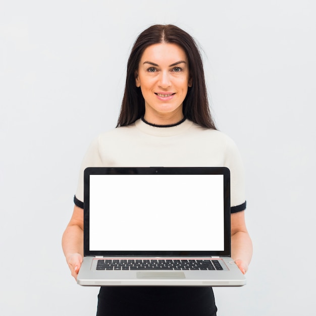 Foto gratuita mujer sosteniendo portátil con pantalla en blanco