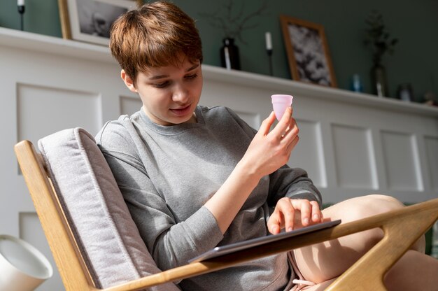 Mujer sosteniendo un producto menstrual reutilizable de tiro medio