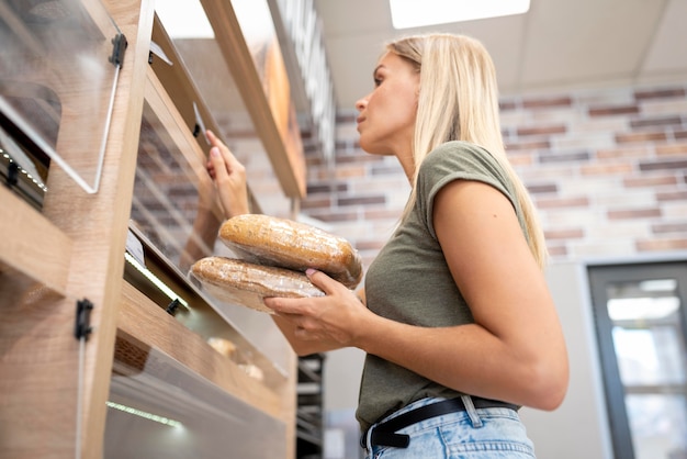 Mujer sosteniendo productos de pastelería tiro medio