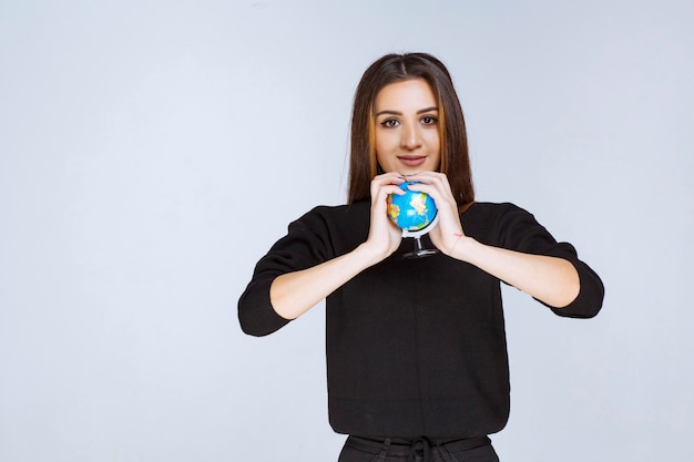 mujer sosteniendo y promocionando un mini globo.