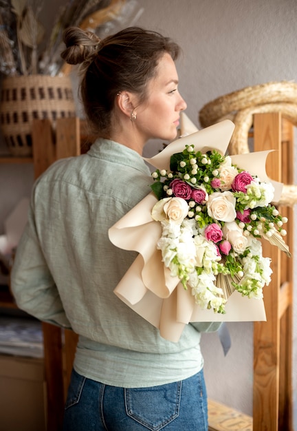 Mujer sosteniendo ramo de flores tiro medio