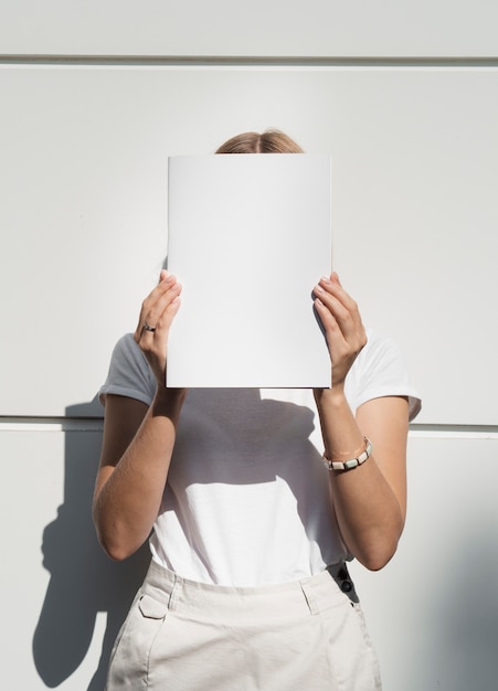 Mujer sosteniendo revista maqueta