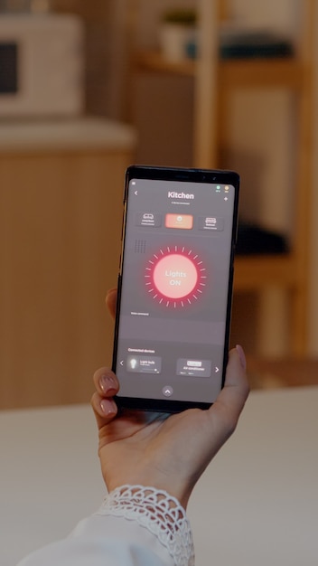 Mujer sosteniendo smartphone con aplicación de control de iluminación