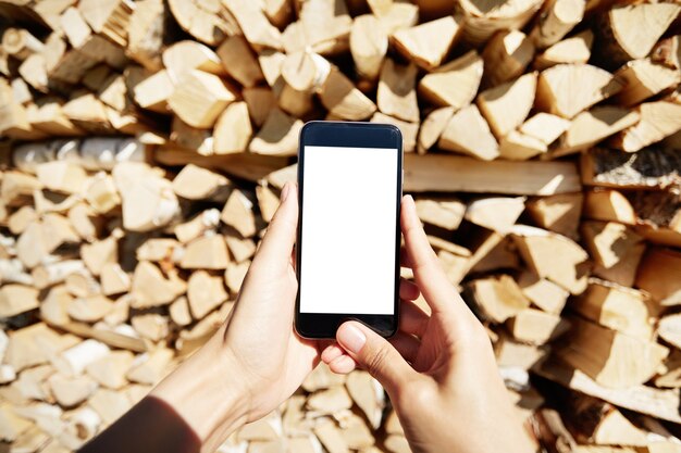 Mujer sosteniendo smartphone con pantalla en blanco en blanco