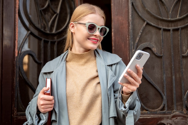 Mujer sosteniendo smartphone tiro medio