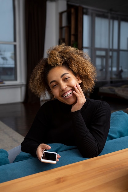 Foto gratuita mujer sosteniendo smartphone tiro medio