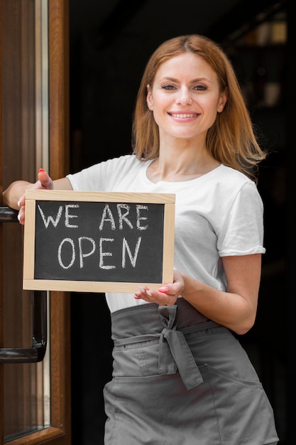 Mujer sosteniendo somos señal abierta