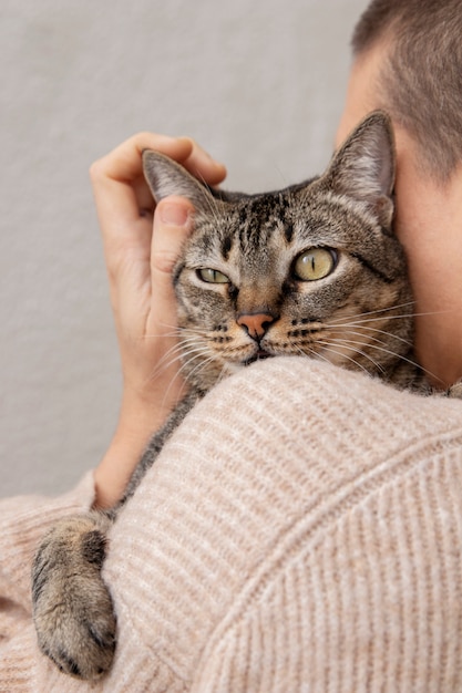 Mujer sosteniendo su adorable gatito en el interior