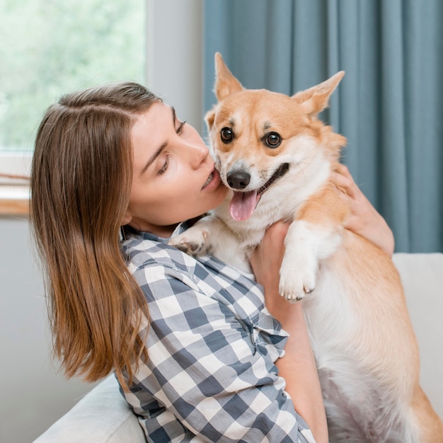 Foto gratuita mujer sosteniendo su adorable perro mascota