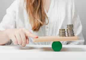 Foto gratuita mujer sosteniendo su dedo en equilibrio con las monedas