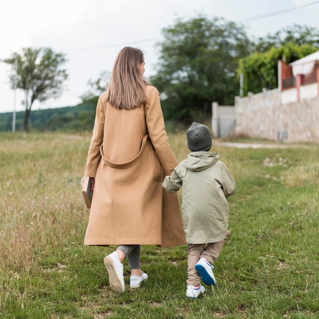 Mujer sosteniendo a su hijo de la mano