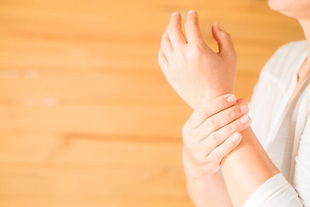 mujer sosteniendo su muñeca Síndrome de Office sintomático