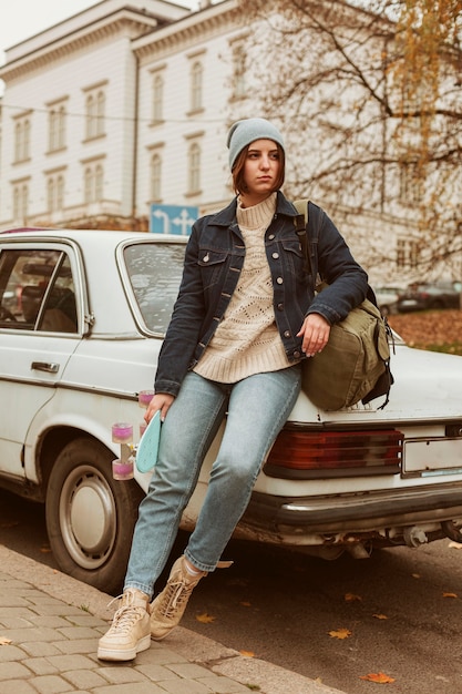 Mujer sosteniendo su patineta mientras está sentado en el coche