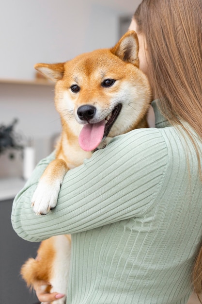 Mujer sosteniendo a su perro en sus brazos