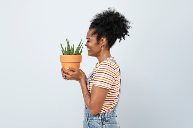 Mujer sosteniendo una suculenta aloe vera en macetas