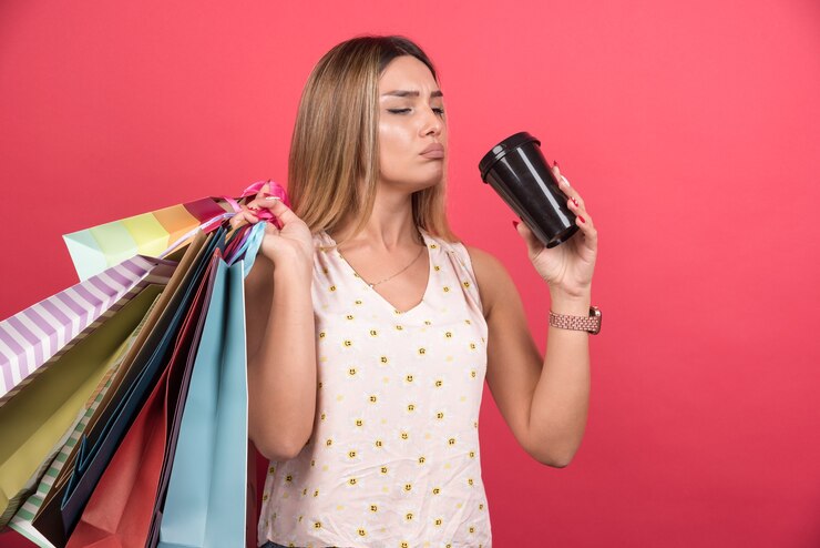 Foto gratuito mujer sosteniendo sus bolsas de la compra y bebiendo una taza de café.