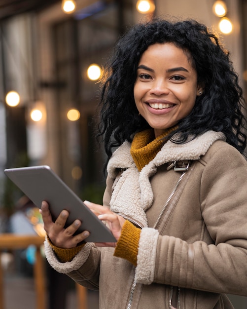 Foto gratuita mujer sosteniendo una tableta fuera