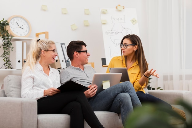 Foto gratuita mujer sosteniendo una tableta y hablando de negocios con sus colegas