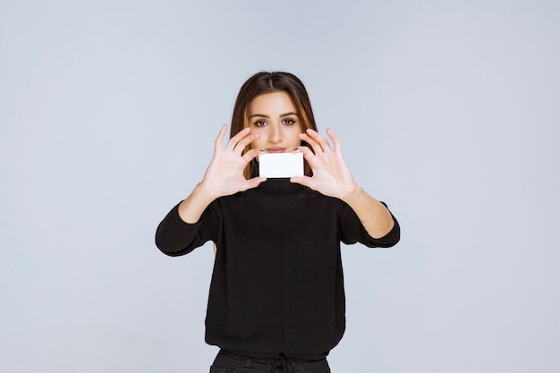 mujer sosteniendo una tarjeta de visita y presentándose.