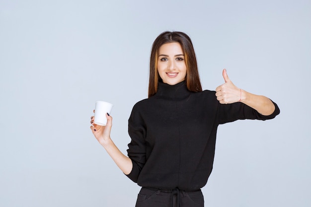 mujer sosteniendo una taza de café y disfrutando del sabor.