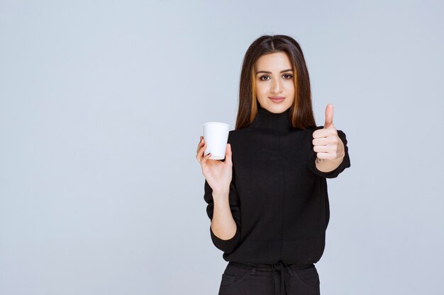 mujer sosteniendo una taza de café y disfrutando del sabor.