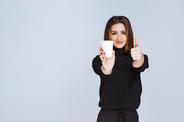 mujer sosteniendo una taza de café y disfrutando del sabor.