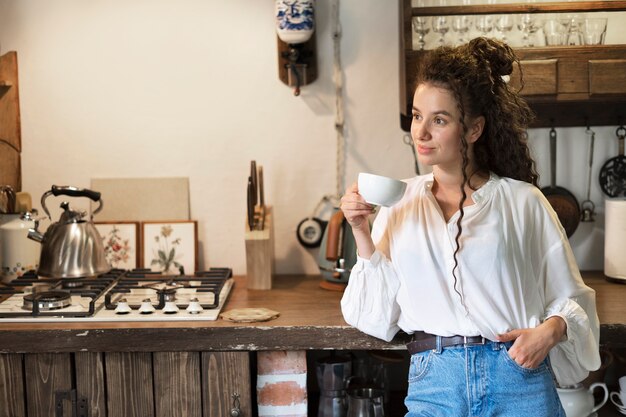 Mujer sosteniendo taza de café tiro medio