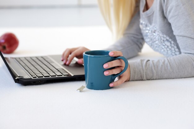 Mujer sosteniendo una taza de limón en el escritorio