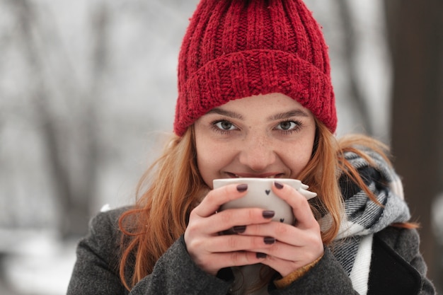 Mujer sosteniendo una taza de té cerca de su cara