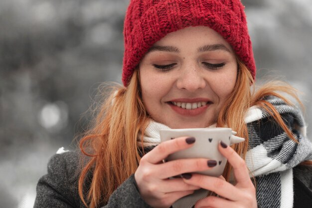 Mujer sosteniendo una taza de té y sonrisas