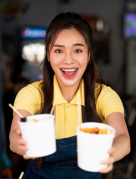 Mujer sosteniendo tazas de tiro medio