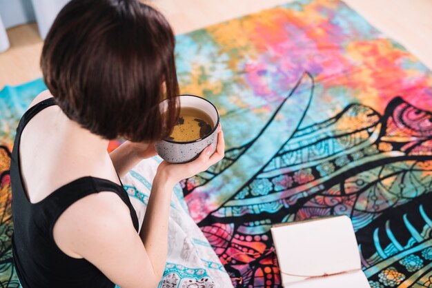 Mujer sosteniendo tazón de sopa saludable durante el yoga