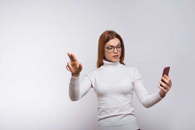Mujer sosteniendo el teléfono celular y presionando el botón virtual