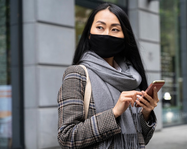 Mujer sosteniendo teléfono de tiro medio