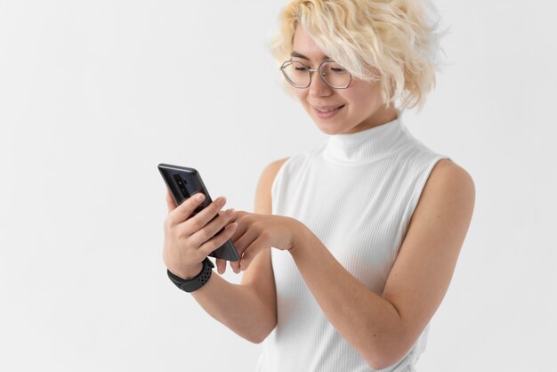 Mujer sosteniendo un teléfono de tiro medio