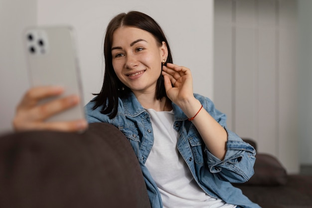 Mujer sosteniendo un teléfono de tiro medio