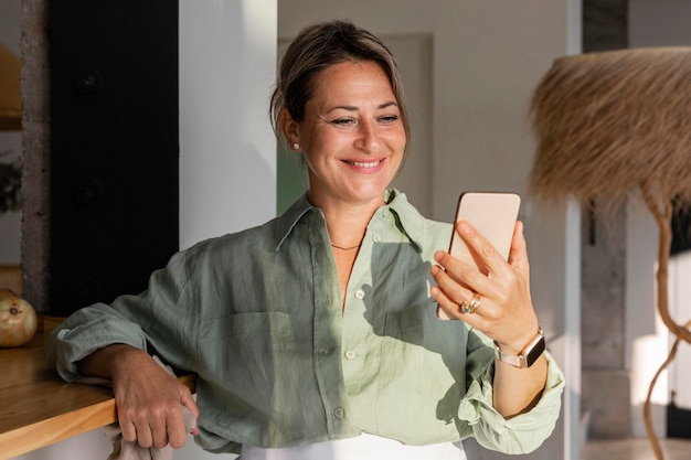 Mujer sosteniendo un teléfono de tiro medio