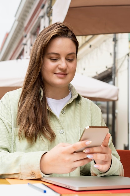 Mujer sosteniendo un teléfono de tiro medio