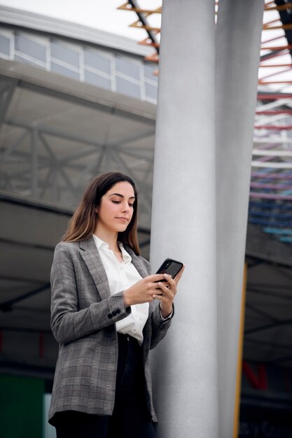 Mujer sosteniendo un teléfono de tiro medio