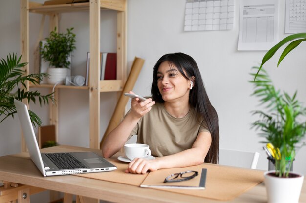 Mujer sosteniendo un teléfono de tiro medio