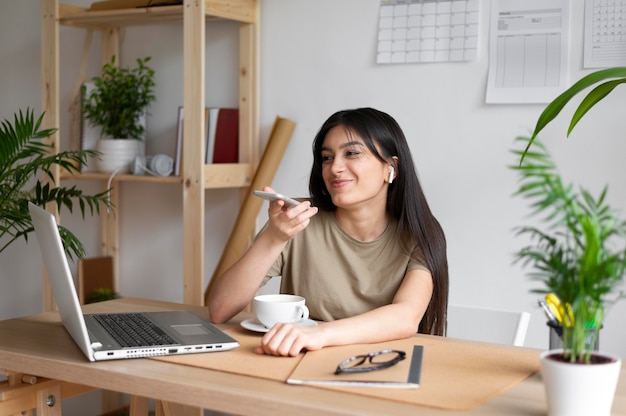 Mujer sosteniendo un teléfono de tiro medio