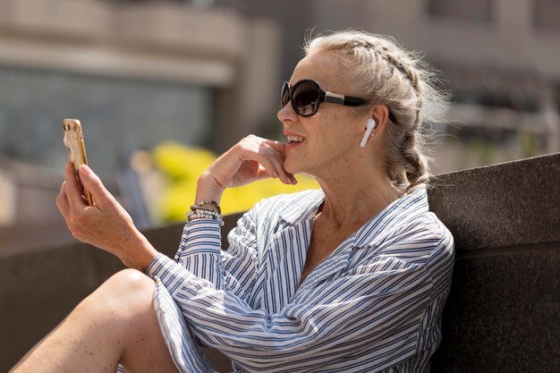 Mujer sosteniendo un teléfono de tiro medio