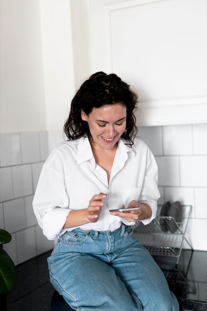 Mujer sosteniendo un teléfono de tiro medio