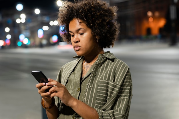 Mujer sosteniendo un teléfono de tiro medio