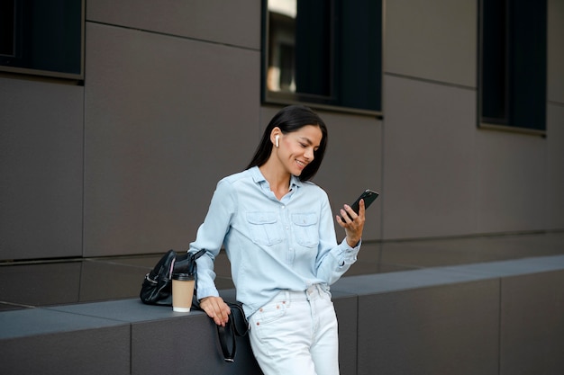 Mujer sosteniendo un teléfono de tiro medio