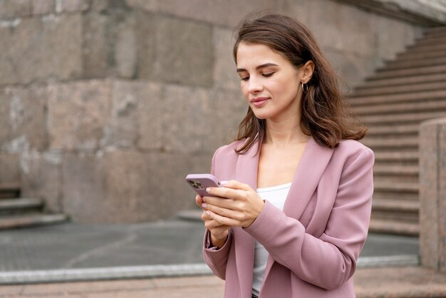 Mujer sosteniendo un teléfono de tiro medio