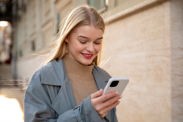 Mujer sosteniendo un teléfono de tiro medio